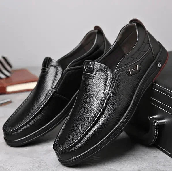 Black Men's Leather Slip-On Shoes — Edward Cushioned Moc-Toe Business Loafers - Pair Leaning