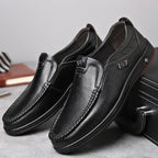 Black Men's Leather Slip-On Shoes — Edward Cushioned Moc-Toe Business Loafers - Pair Leaning