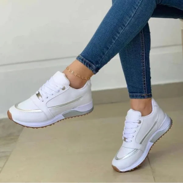 White Women's Chunky Sneakers — Diane Faux Leather Lace-Up Wedge - Front Worn Crossed Ankle